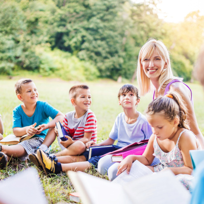 Eine Lehrerin unterrichtet eine Gruppe Kinder im Freien