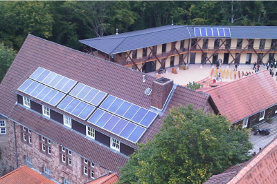 Luftaufnahme der Burg Ludwigstein auf deren Dächern Solarkollektoren verbaut sind.
