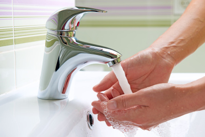 Eine Frau wäscht sich die Hände.