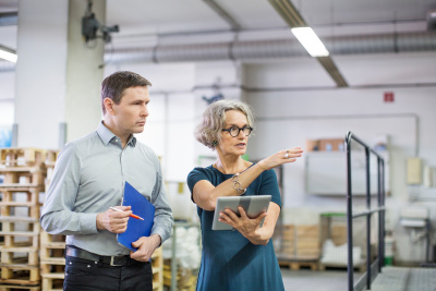 Eine Unternehmerin im Lager bei einer kurzen Besprechung