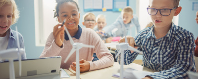 Eine Schülerinnen und Schüler hantieren im Unterricht mit einem Windrad-Modell