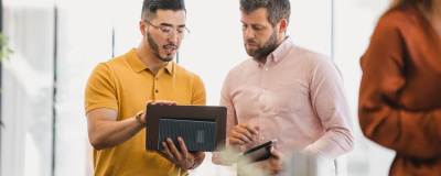 Zwei Männer sehen sich eine Darstellung auf einem Tablet an
