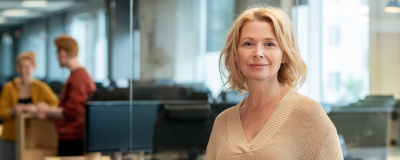 Mitarbeiterin mit Tablet in der Hand stehend vor einem Büro