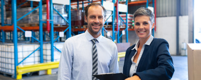 Ein Unternehmer und eine Unternehmerin in der Lagerhalle ihres Betriebes