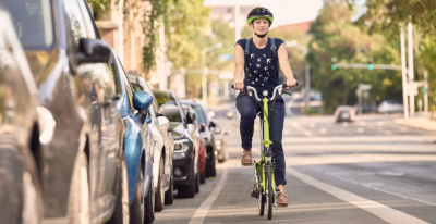 Radfahrerin mit Klapprad im Straßenverkehr